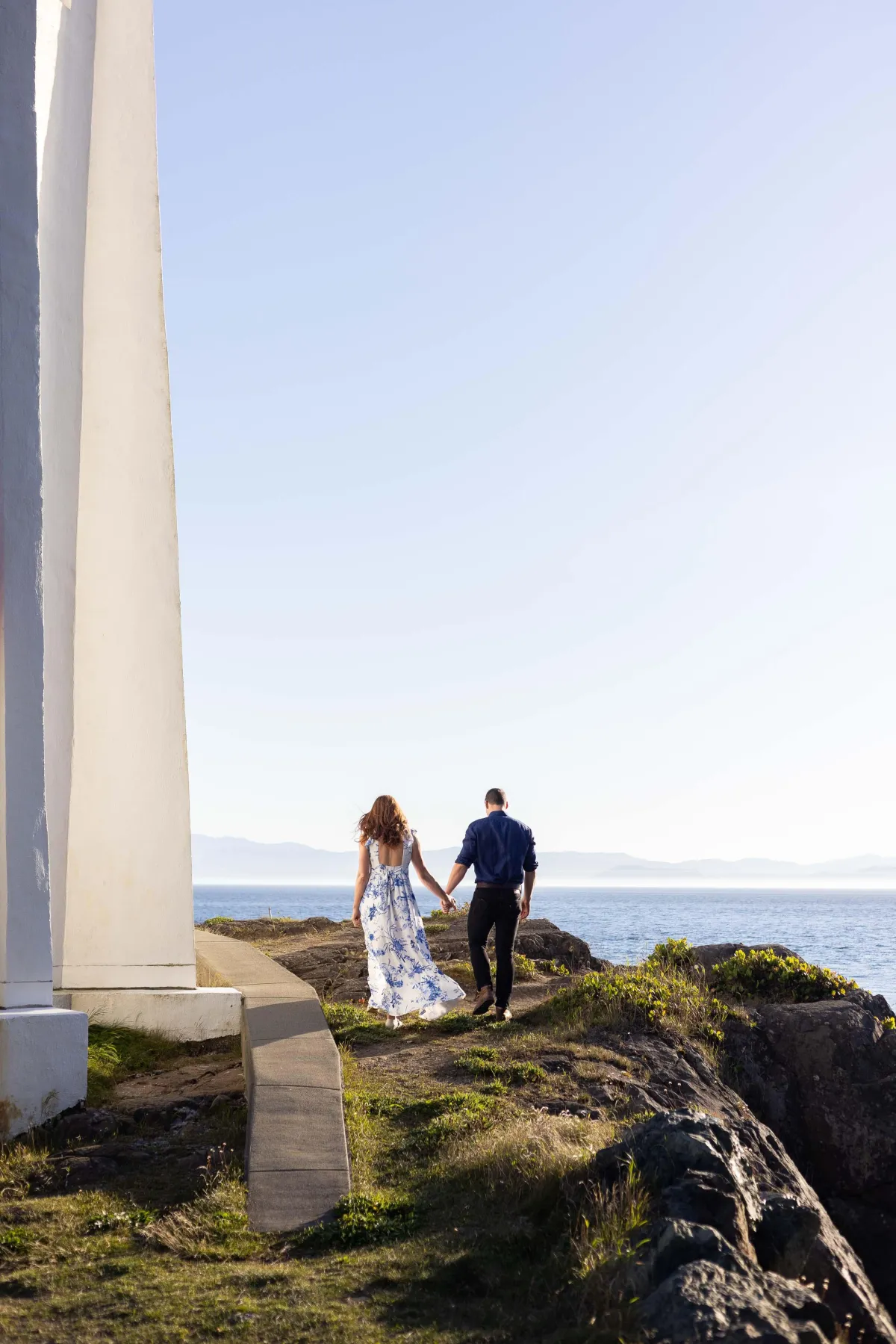 Couple walking along the cliffs by Sheringham Point Lighthouse