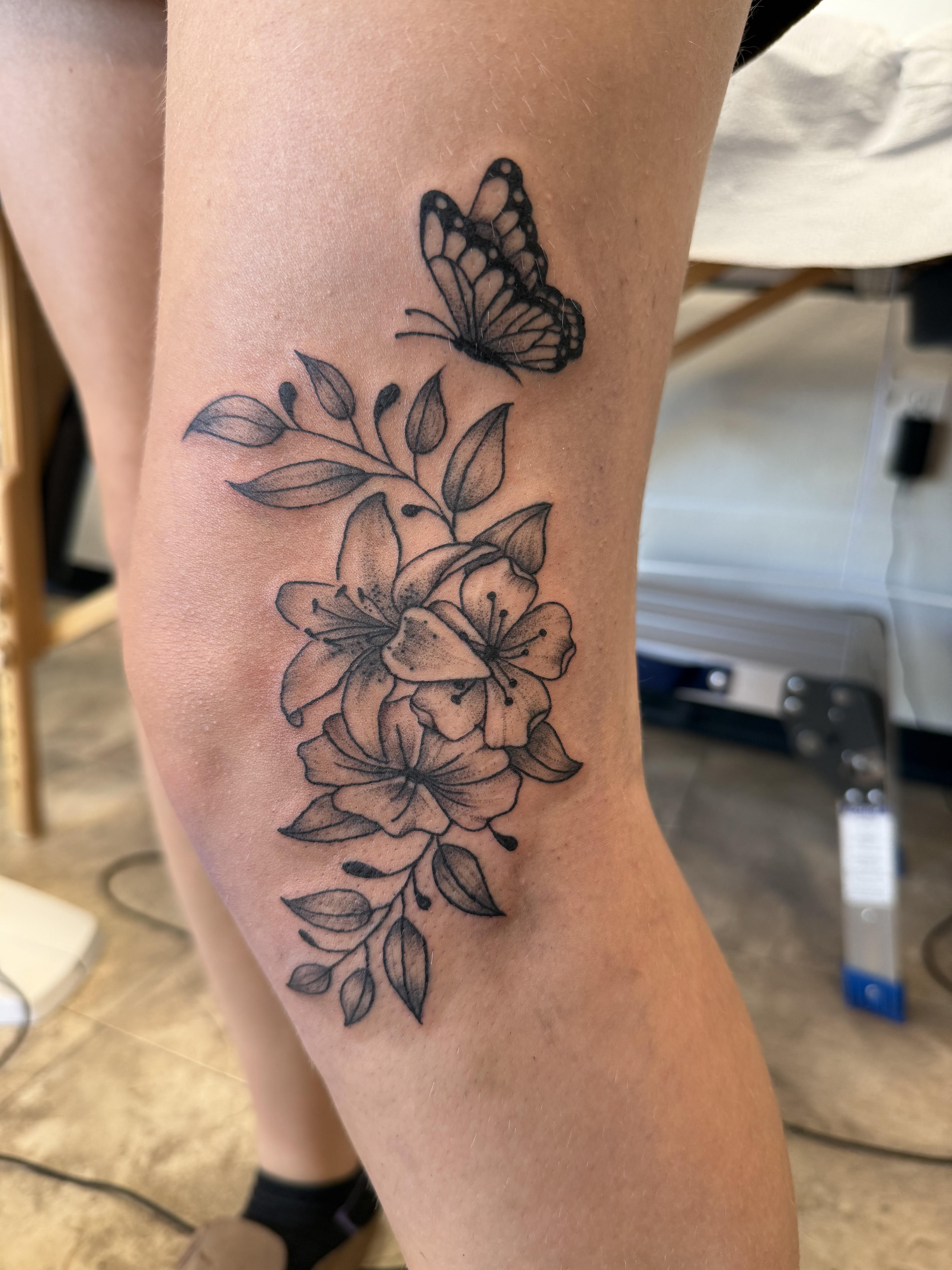 Photo of client's leg with a floral tattoo by Aiden at Red Arbor Tattoo