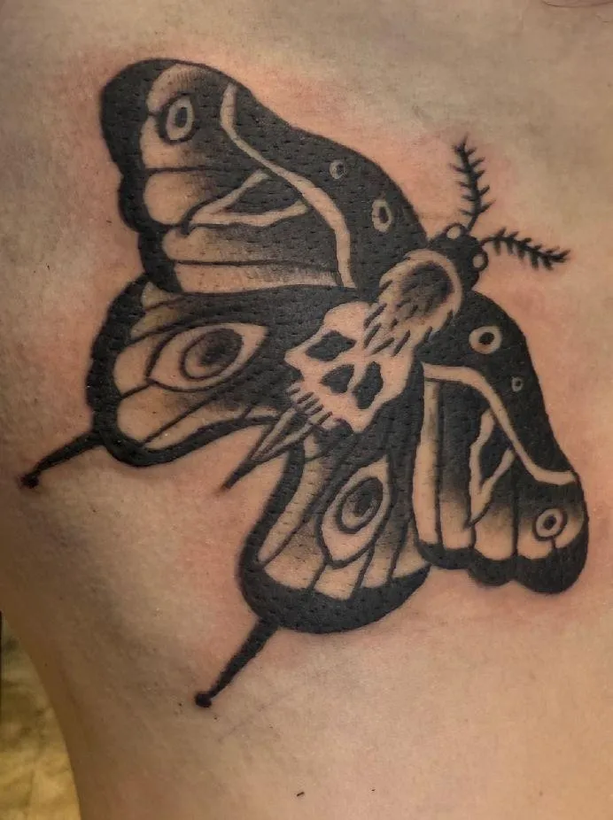 Photo of client's ribs with an American traditional moth tattoo by Aiden at Red Arbor Tattoo
