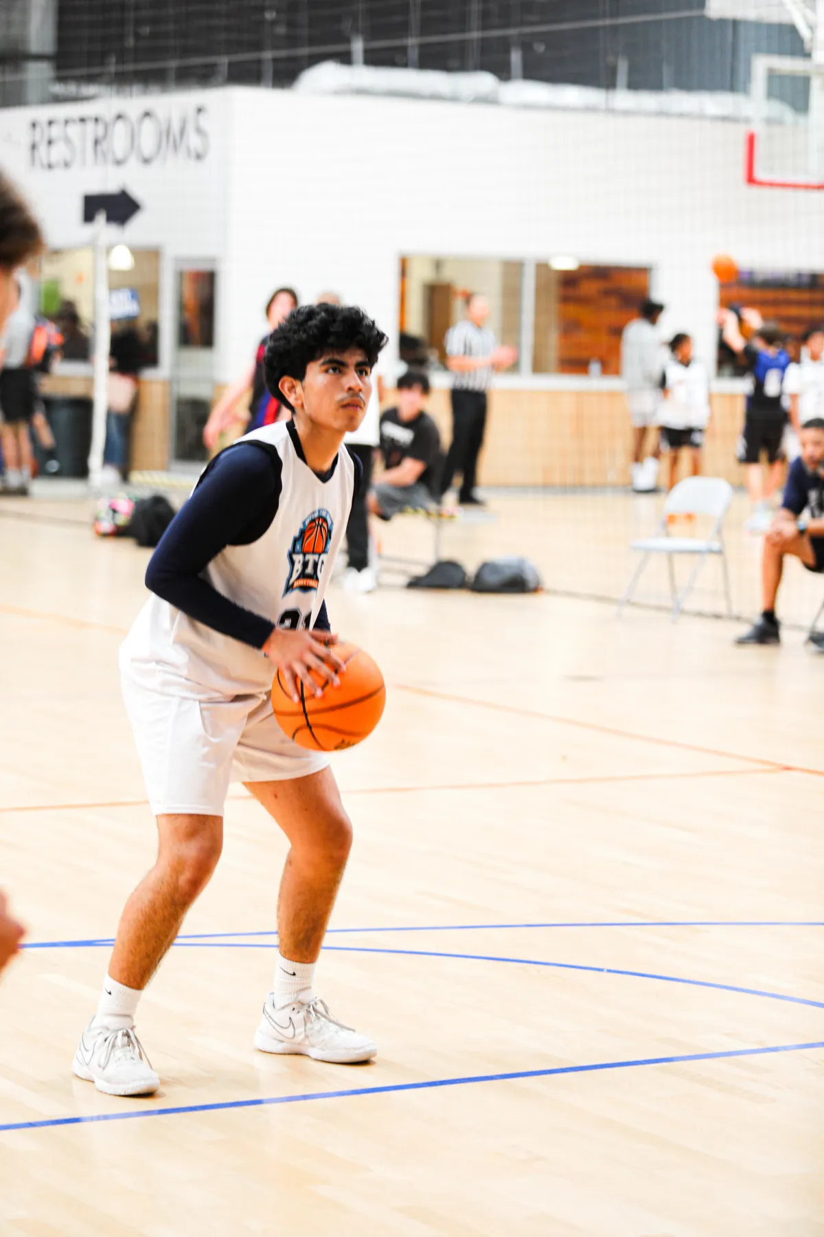 High school boy shooting a basketball at a basketball training camp