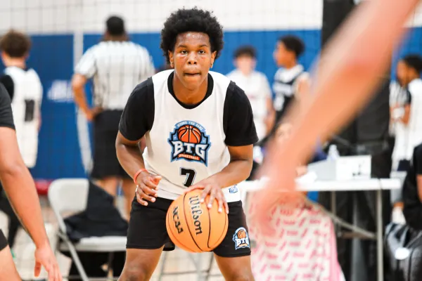High school boy practicing a basketball dribbling drill in an indoor court