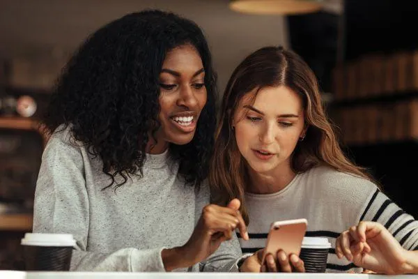 Two women looking at blog