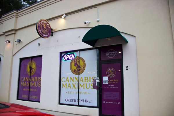 Exterior of Cannabis Maximus dispensary in Brattleboro, Vermont with storefront signage and open sign