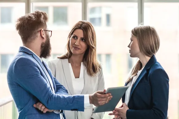 A businessman and two business women talking