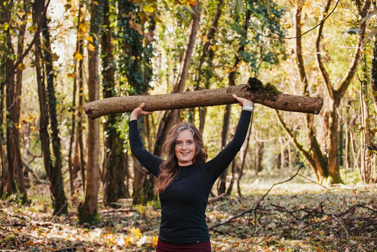 woman lifting a log