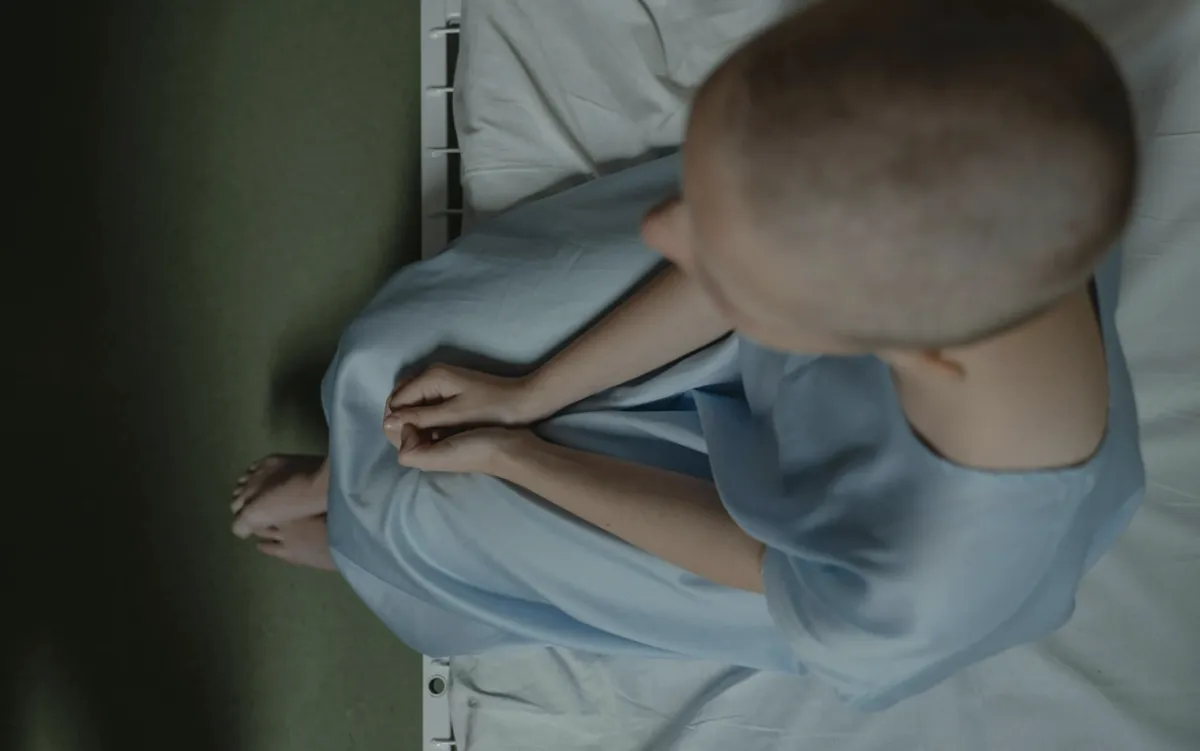 Patient in gown sitting on bed