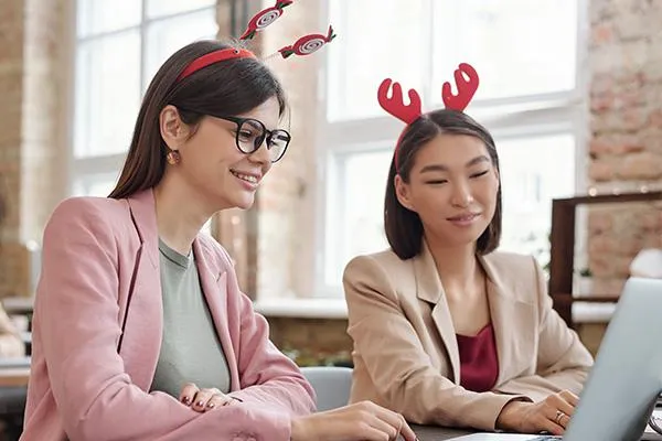 HR specialist and staff wearing reindeer headpieces, discussing ways to maximize health benefits before the year-end, symbolizing SME readiness and care