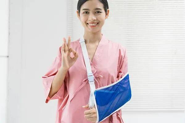 Female staff with arm support giving an OK sign, symbolizing navigating out-of-network care and reimbursement options