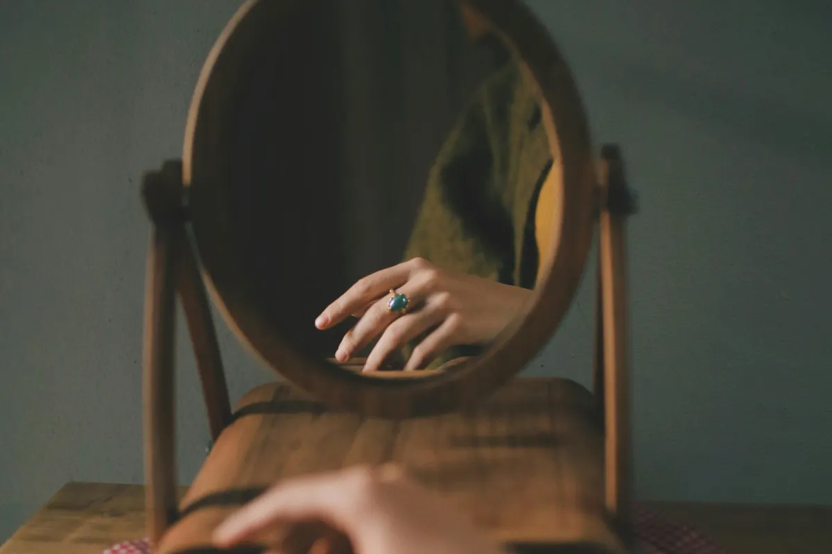 mirror with womans hand visible