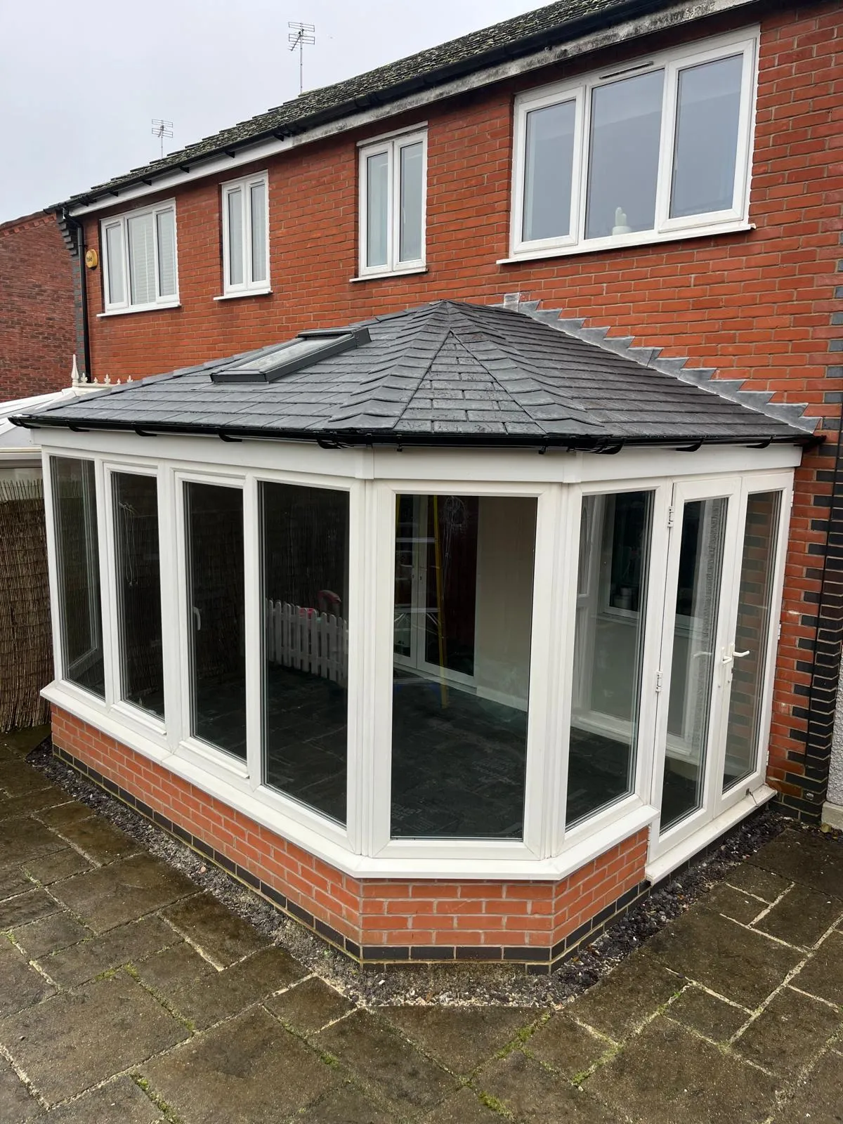A fully insulated bay-fronted conservatory with a modern tiled roof and a Velux window, enhancing natural light and energy efficiency.