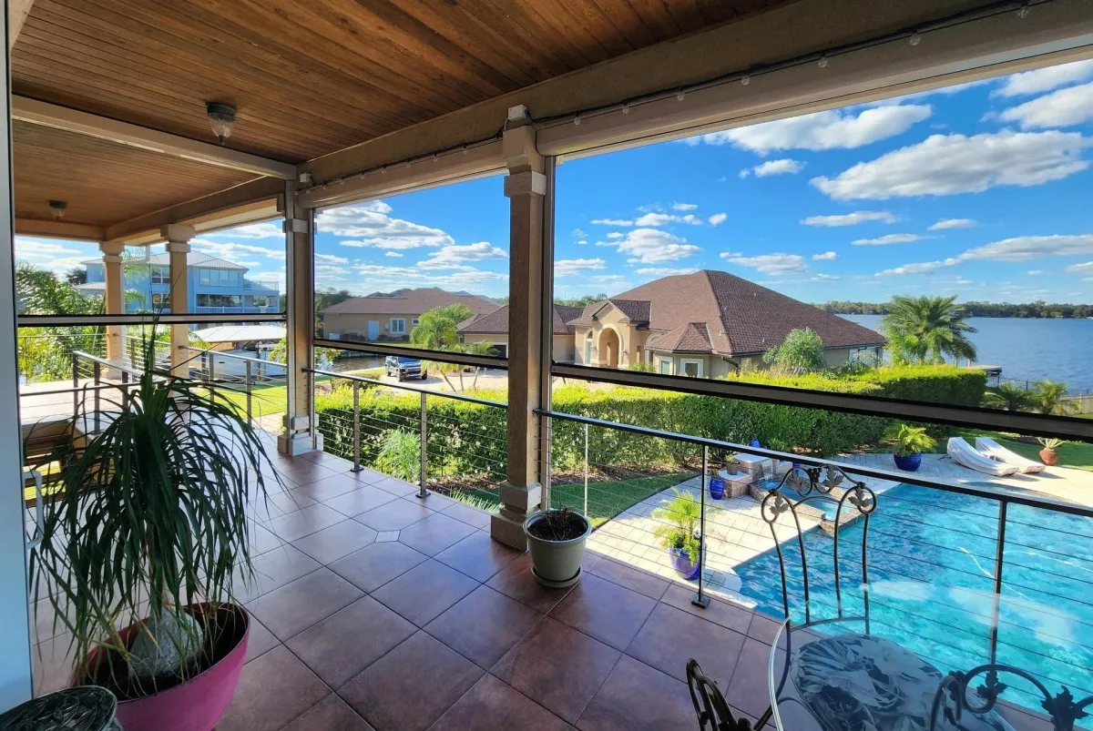 A charming house featuring a welcoming porch and a patio adorned with stylish awnings for shade and comfort.