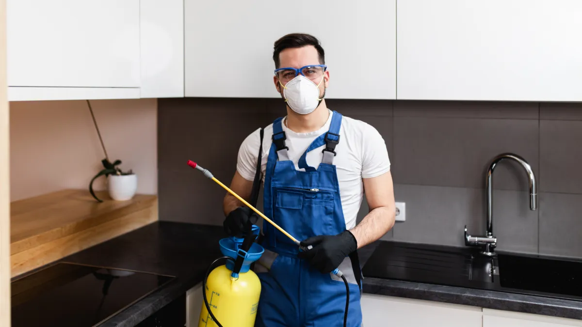 pest control expert holding one of the best commercial pest control products in a kitchen 
