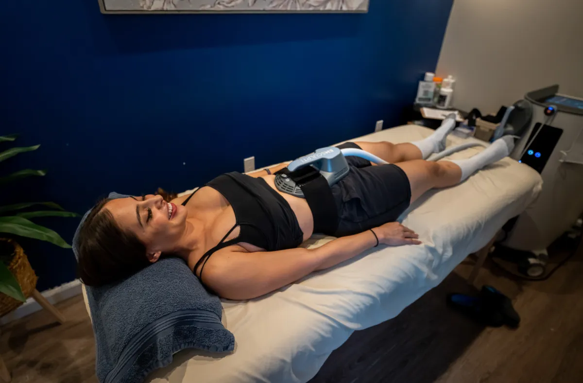 A woman receiving EmSculpt treatment