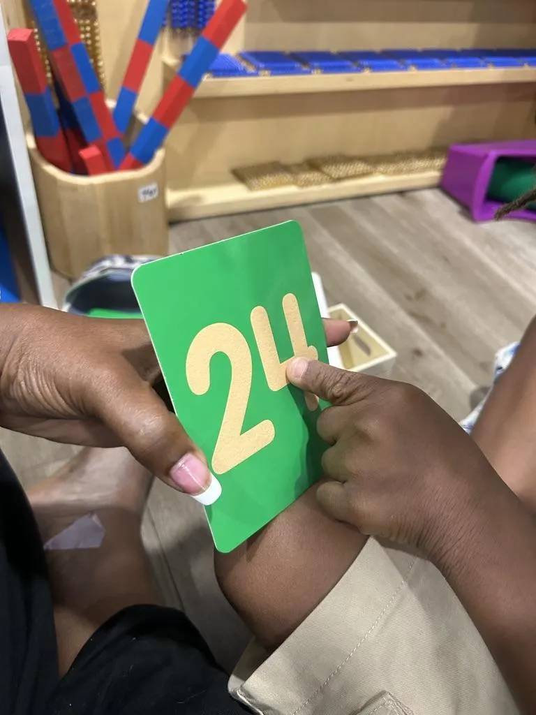 Teacher working with child and Sandpaper letters
