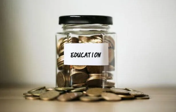 Change in glass jar labeled "education"