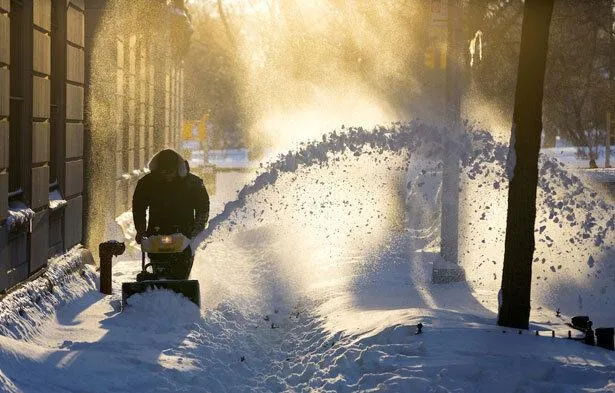 Man snowblowing snow in winter tundra