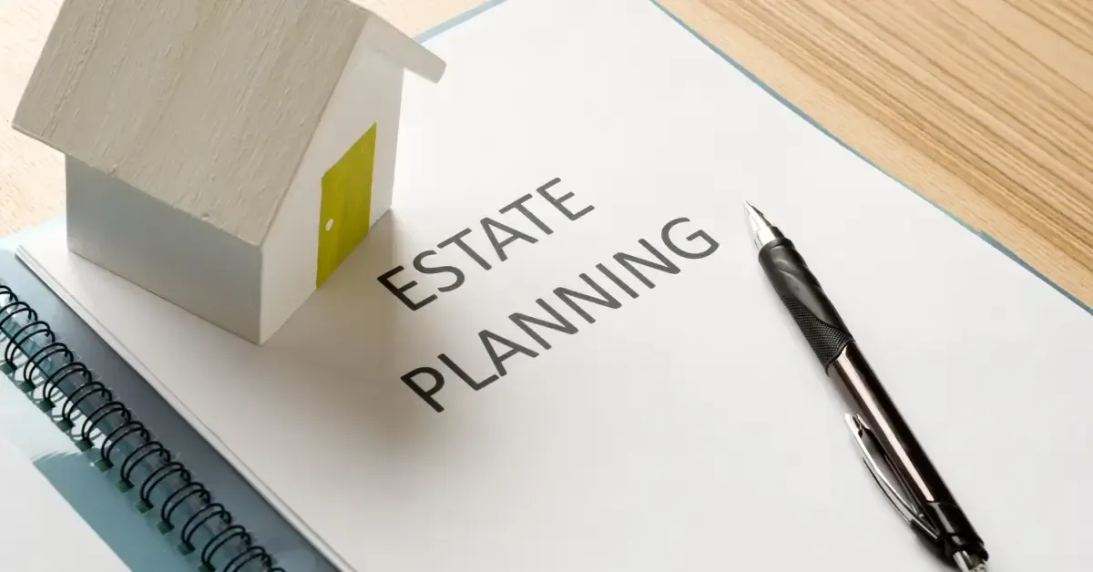Estate planning document on a desk with a pen and a small model house placed on top.