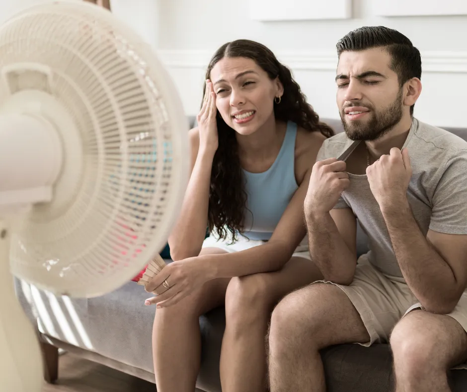 Homeowners uncomfortable in a hot Salem, Oregon house due to an AC blowing warm air, needing air conditioner repair.