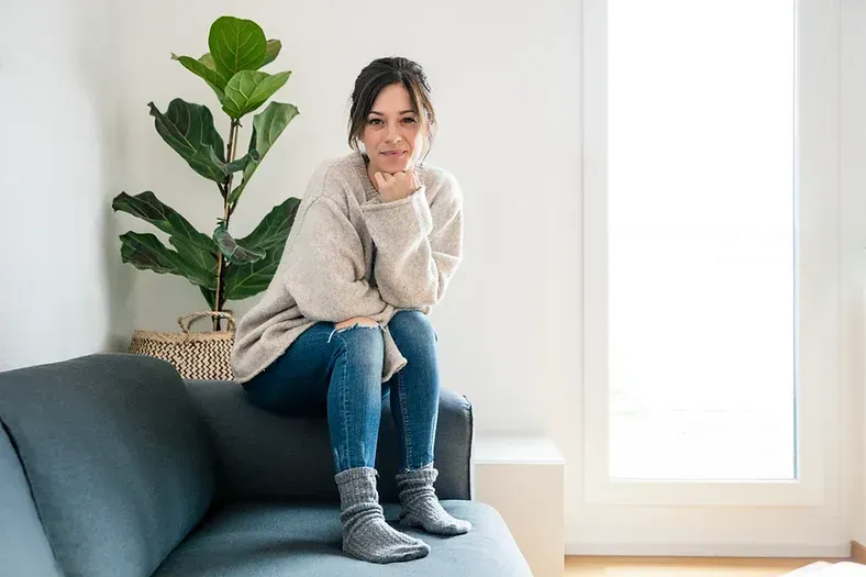 Woman sitting on end of couch