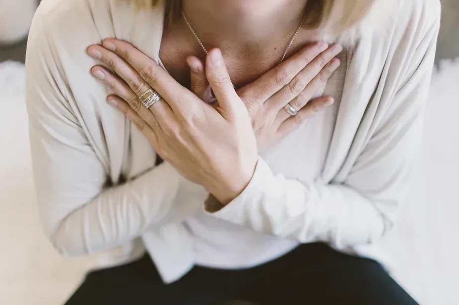 Woman with hands over heart