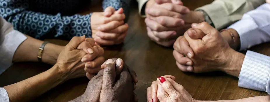 Hands of group praying