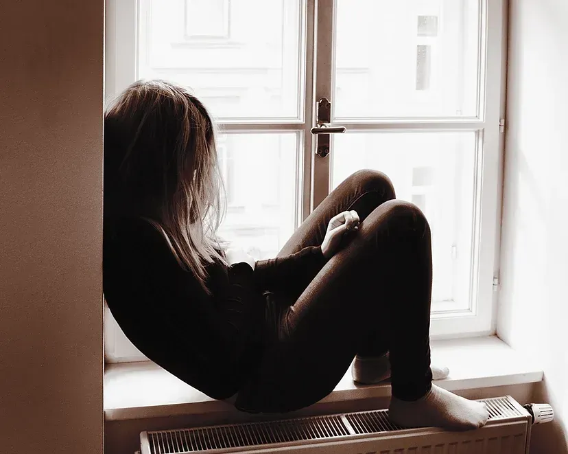 Sad woman sitting in the window