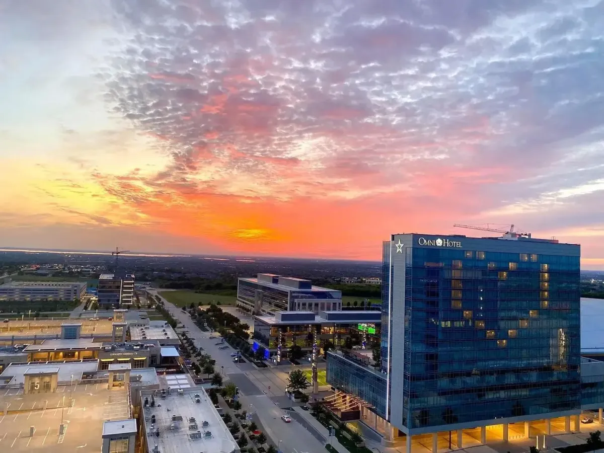 Vibrant sunset over cityscape with glowing heart-lit hotel.