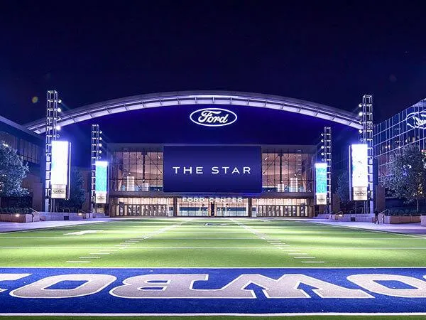 Glowing Ford Center at The Star—Cowboys' home under night lights.