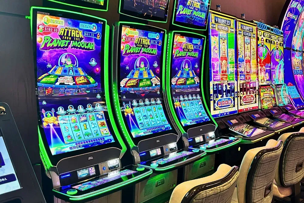 Colorful slot machines in a casino with comfortable seating arrangement.