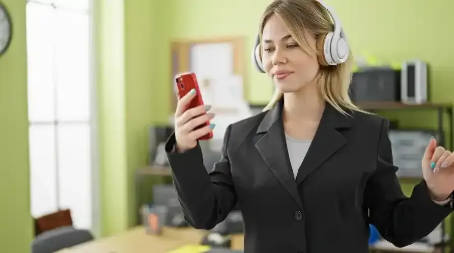 Businesswoman using a smartphone for a call in an office setting – pay per call benefits