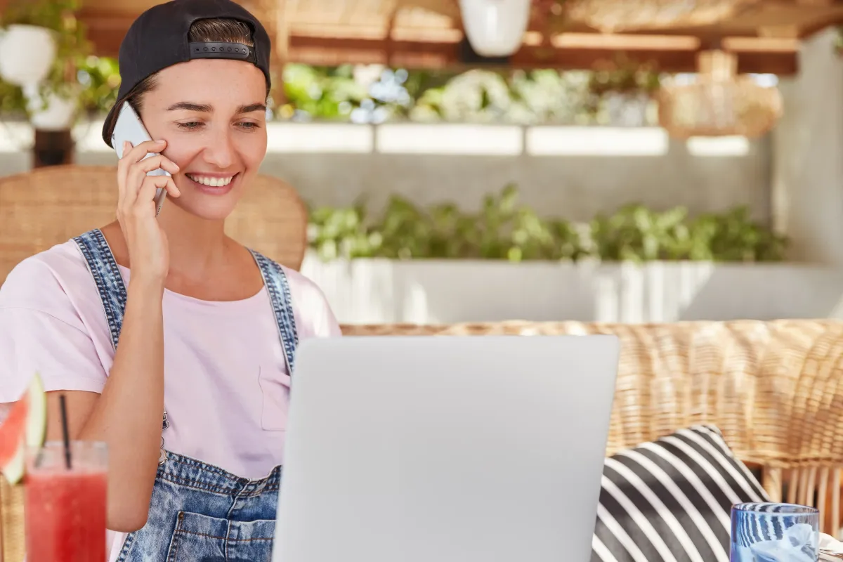 Woman on a phone call, working on a laptop, Pay Per Call affiliate marketing setup.