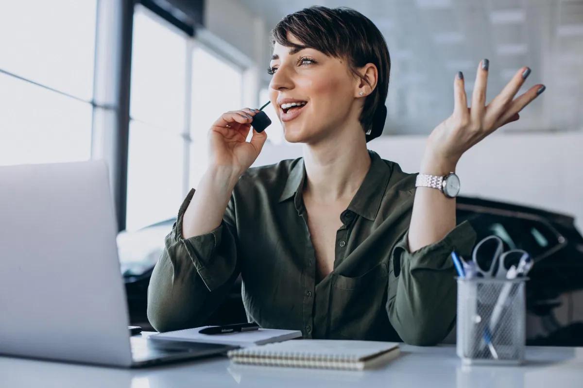 Businesswoman using a headset while working on a Pay Per Call campaign at her desk