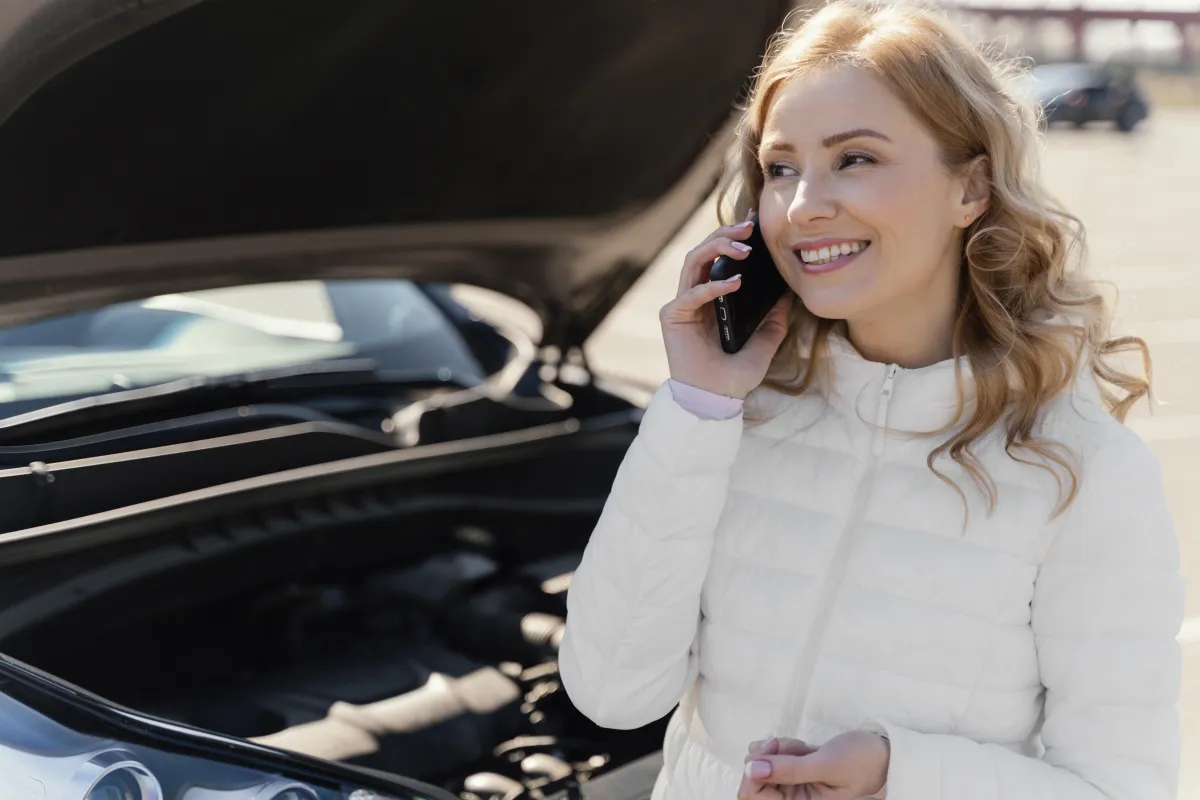 woman on phone by car, showcasing Pay Per Call in the insurance industry.