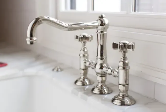 silver water taps in marble sink