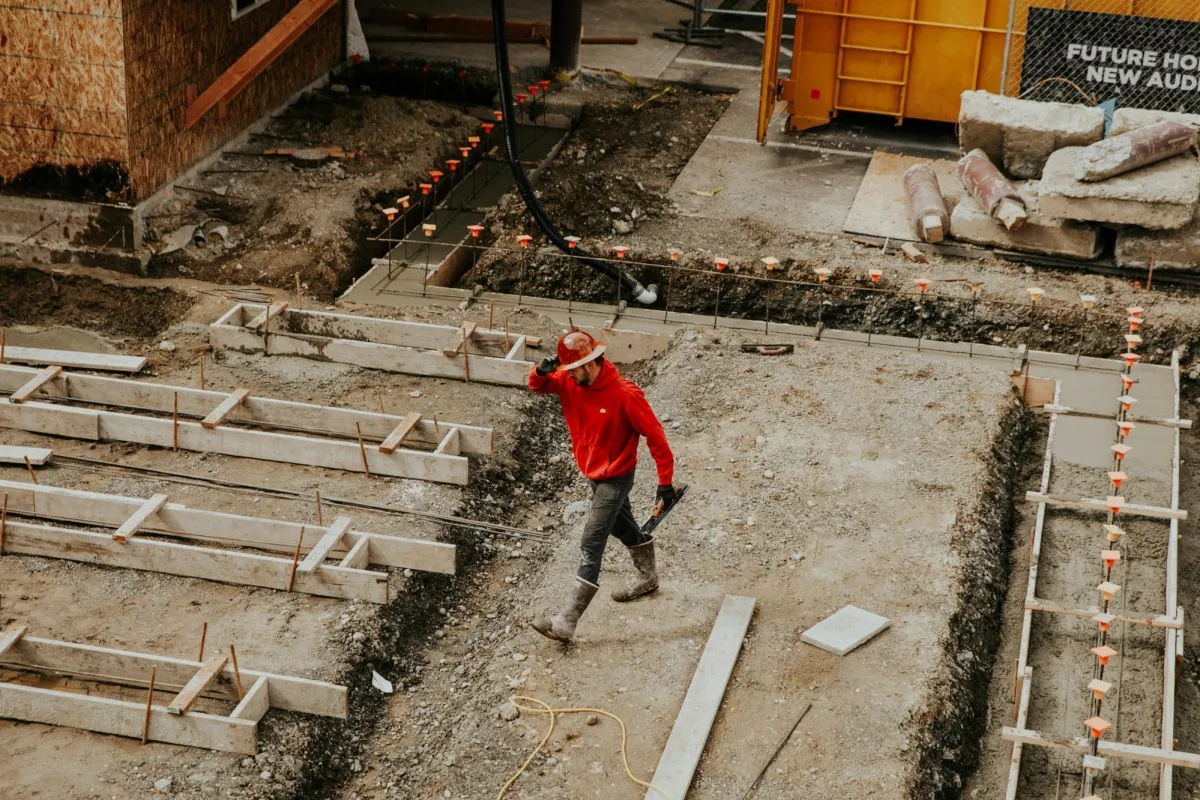 A construction worker walking on a building site, symbolizing the importance of clear communication and careful documentation in resolving contract disputes with your builder.