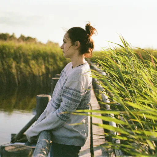 Woman standing on a bridge in a swamp, symbolizing navigating dysfunctional family systems and crossing from survival into healing and authenticity.