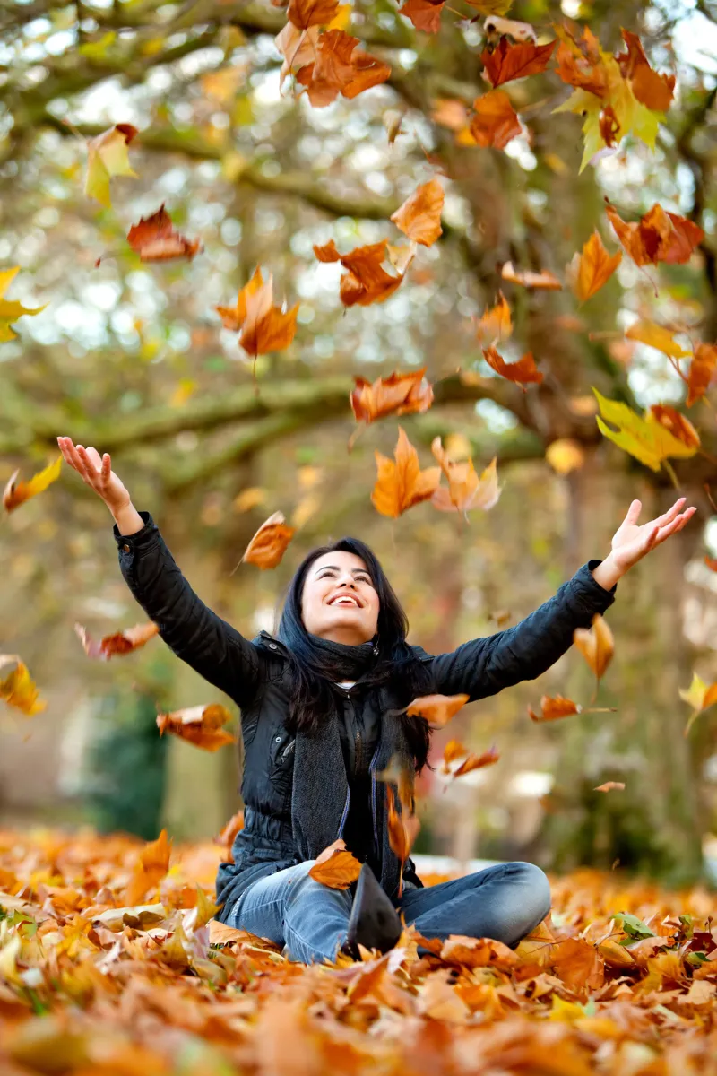 woman enjoying the fall leaves