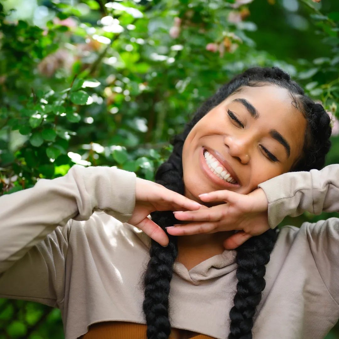 Smiling Blasian woman applying Korean skincare products, showcasing the diversity of K-beauty users