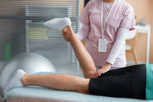 Therapist stretching a patient's leg.