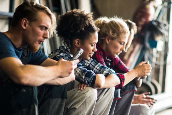 Group of frustrated individuals sitting around with smartphones, indicating stress and frustration due to lack of internet connectivity.