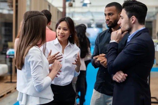 Image depicting people engaged in conversation at a networking event, showcasing the silent language of networking.