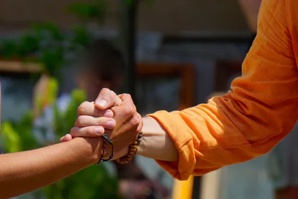 An illustration showing the difference between trust and credibility. On one side, a person shakes hands with another, symbolizing trust built through personal relationships and reliability. On the other side, another person holds a certificate or a badge, representing credibility established through proven expertise, qualifications, and recognition by others.