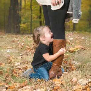 Child clinging to Mom's leg