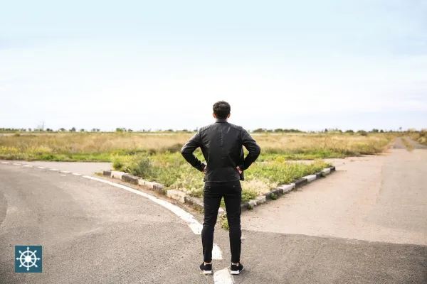 Person at a crossroads, pausing before choosing a path — symbolizing decision-making in complex situations