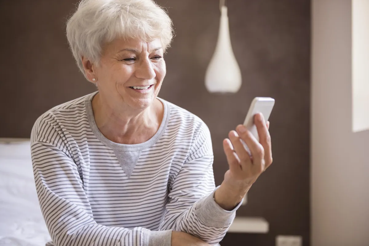 Older woman using smartphone and smiling