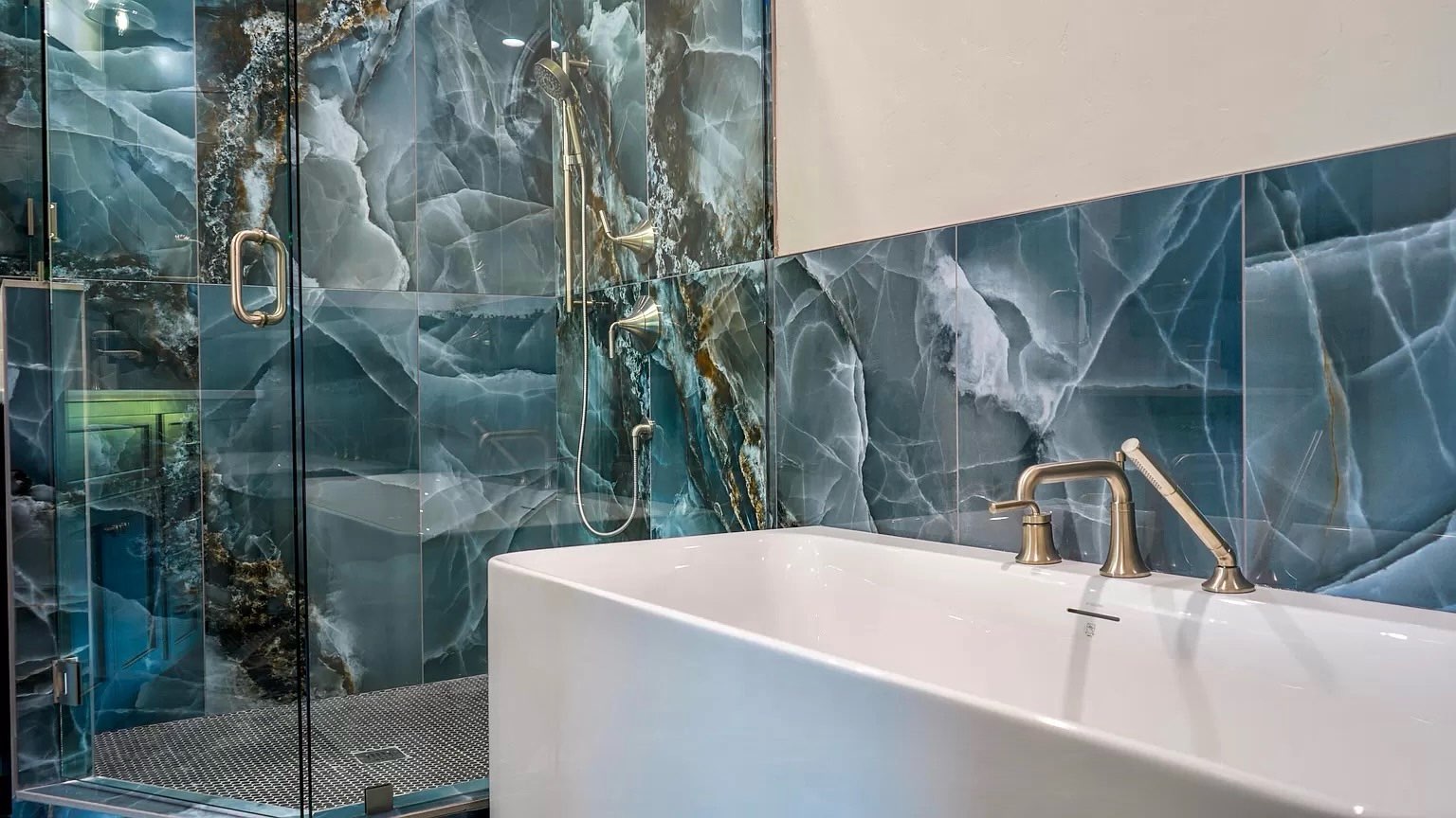 Modern kitchen remodel with black cabinets, quartz countertops, pendant lights, and marble backsplash