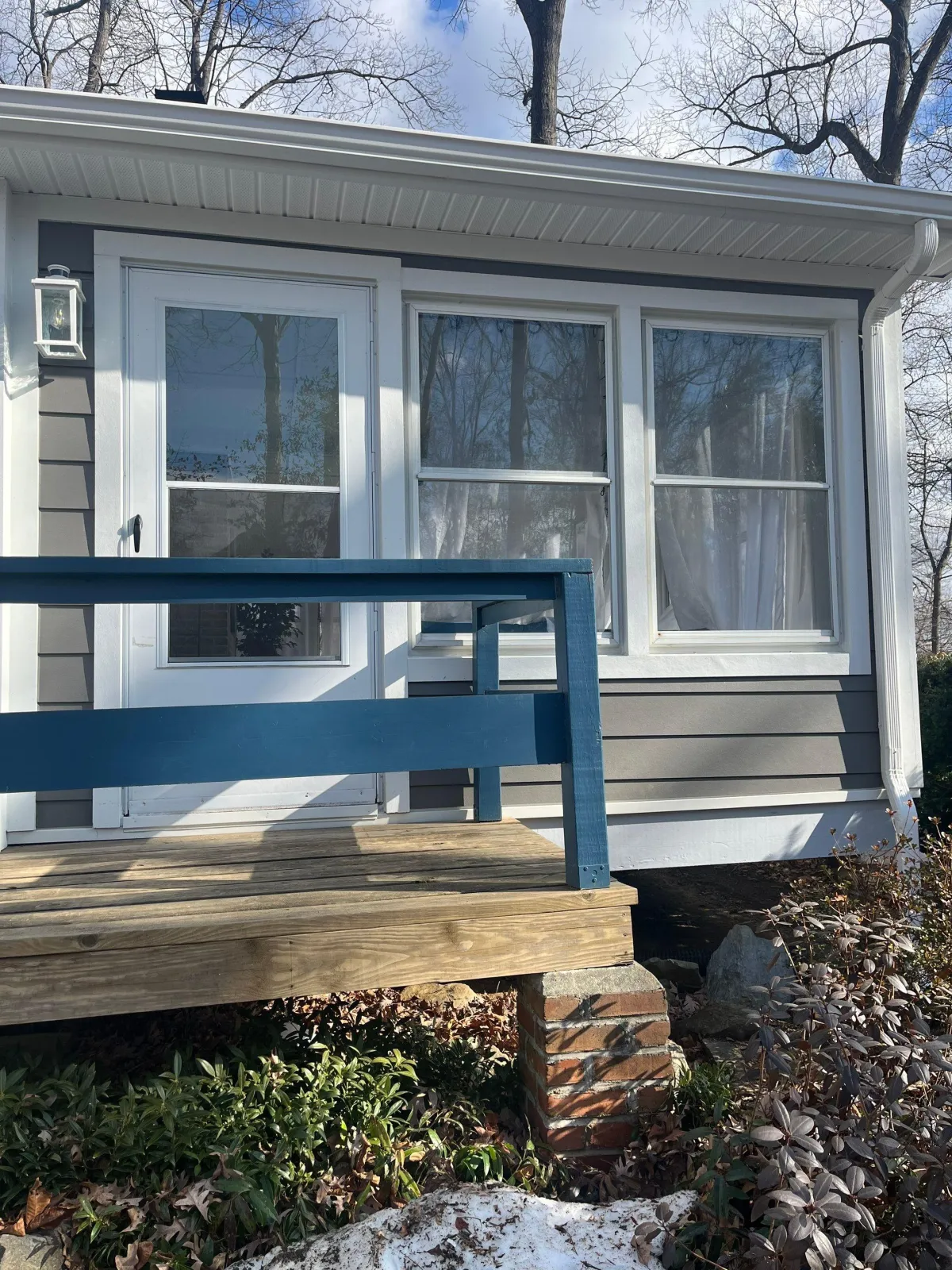 House with new siding, gutters, fascia, and window wraps.