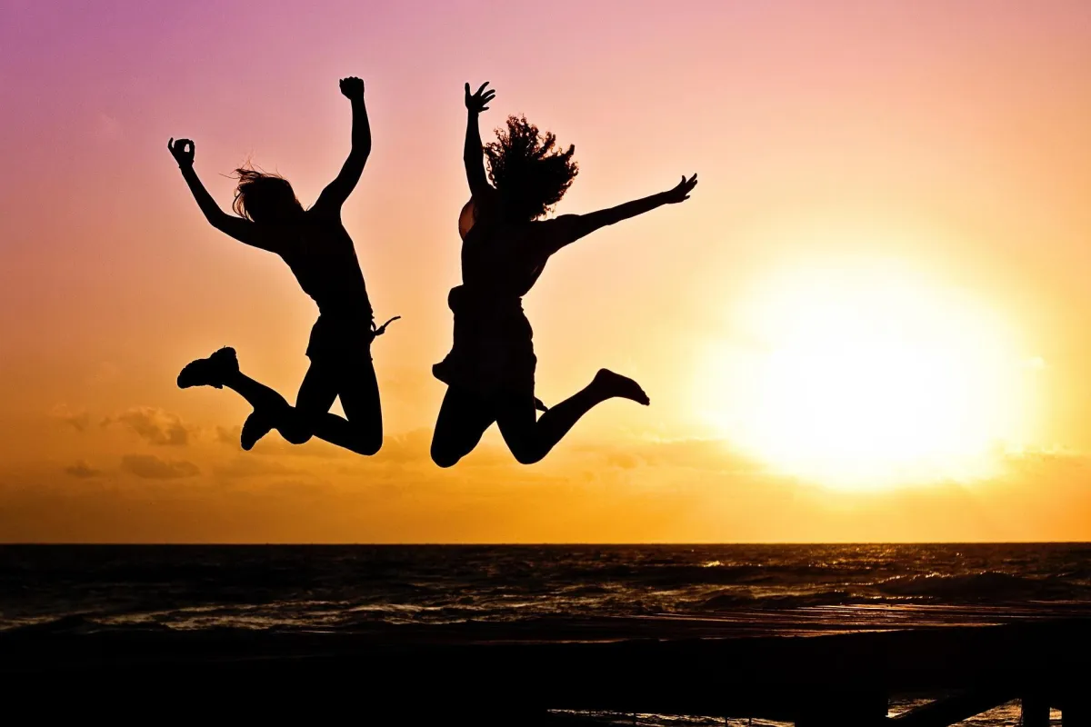 two people jumping on a beach