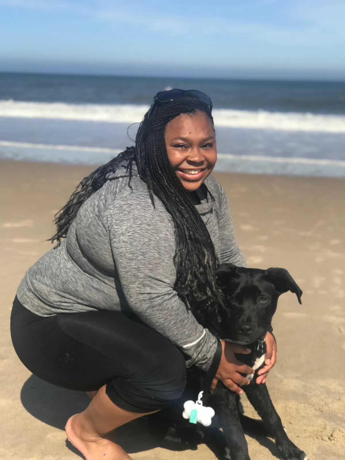 African American woman on the beach with dog