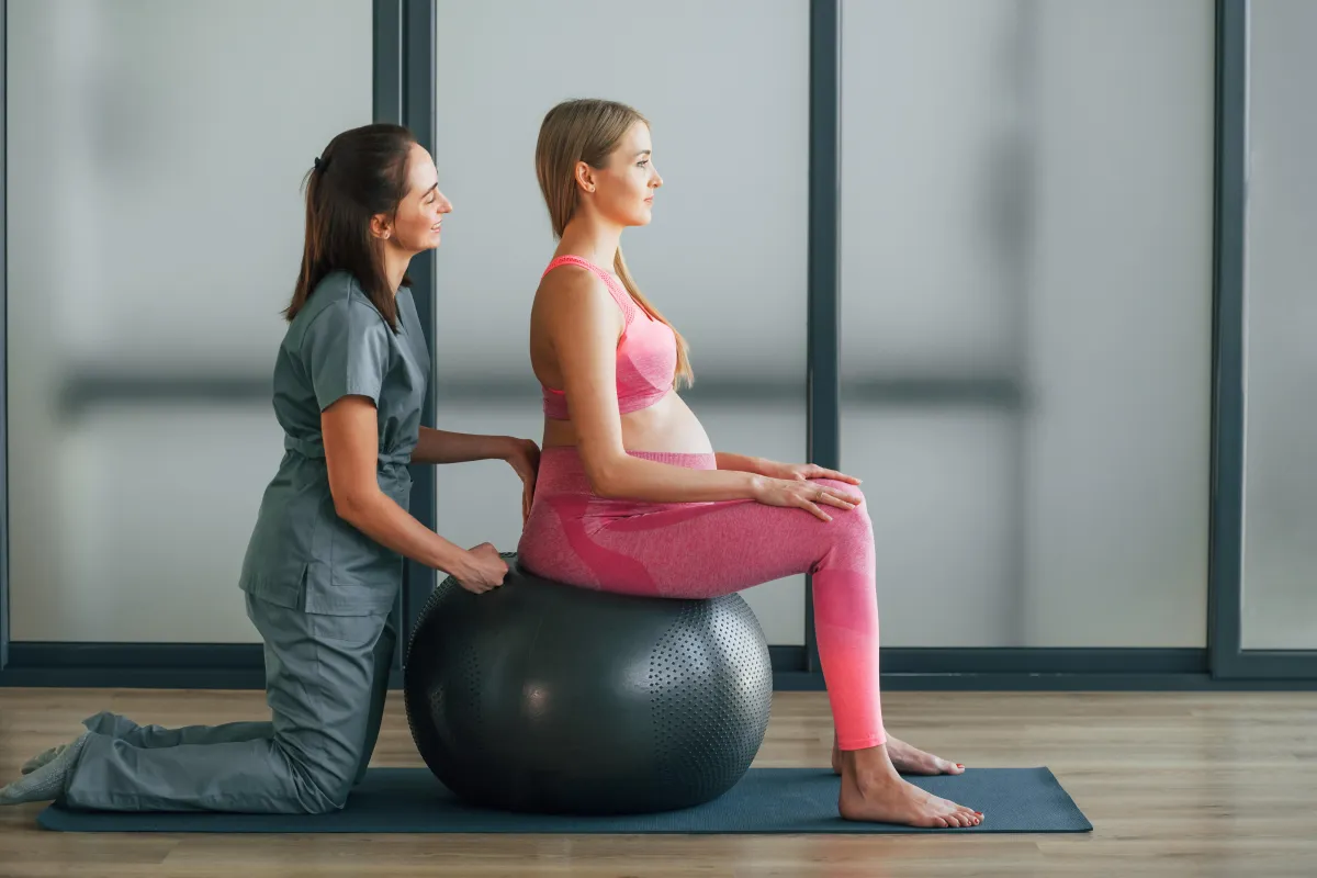 A female patient receiving pelvic physiotherapy in a private clinical setting.